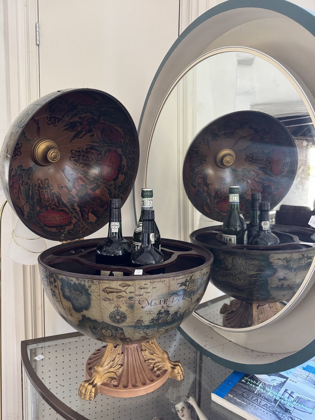 Globebar met zeekaartdecor, geopend met flessen in het binnenwerk
